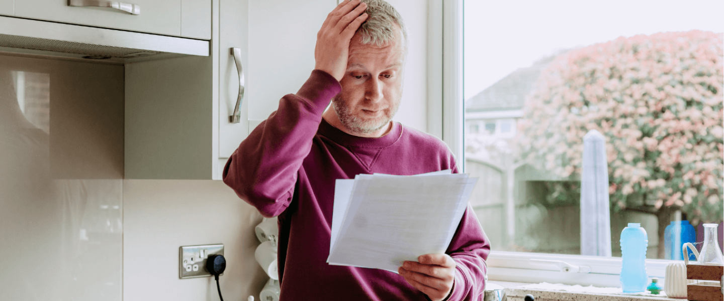 An older man looking at his credit report, wondering how to improve his 550 credit score.