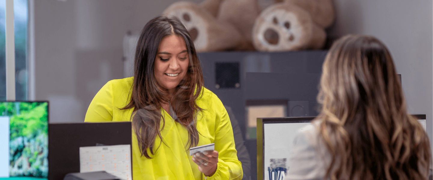A woman talking to an advisor at a credit union about improving her credit score.