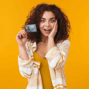Woman holding a credit card in front of a yellow background.