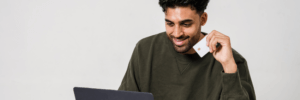 A man on his laptop holding a credit card.